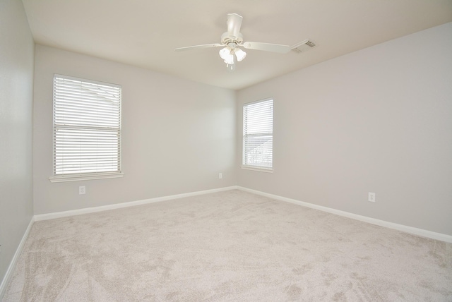 spare room with light colored carpet and ceiling fan