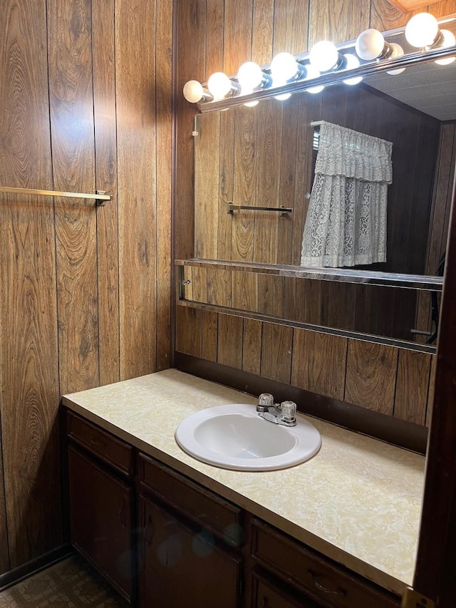 bathroom featuring vanity and wooden walls