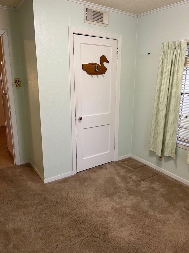 foyer featuring crown molding and carpet floors