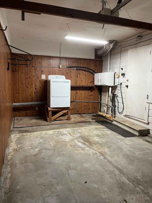 garage featuring washer / clothes dryer and wood walls