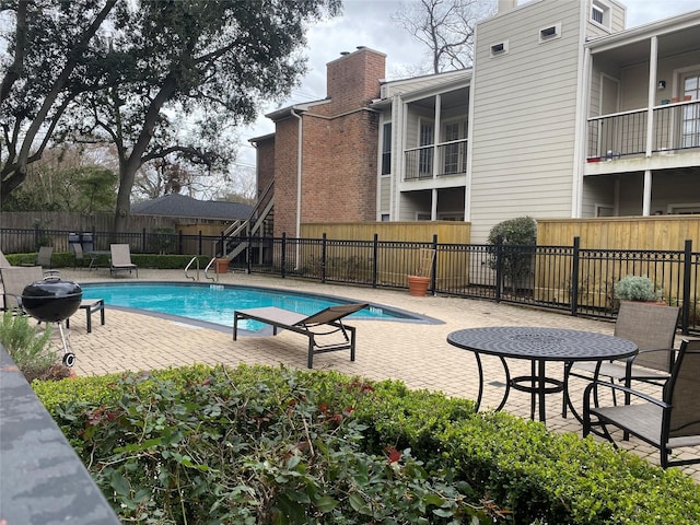 view of swimming pool with a fenced in pool, a grill, a patio area, and fence