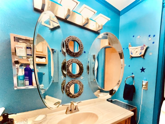 bathroom featuring crown molding and a sink