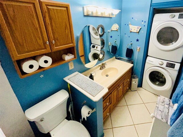 bathroom with stacked washer / drying machine, vanity, toilet, and tile patterned floors