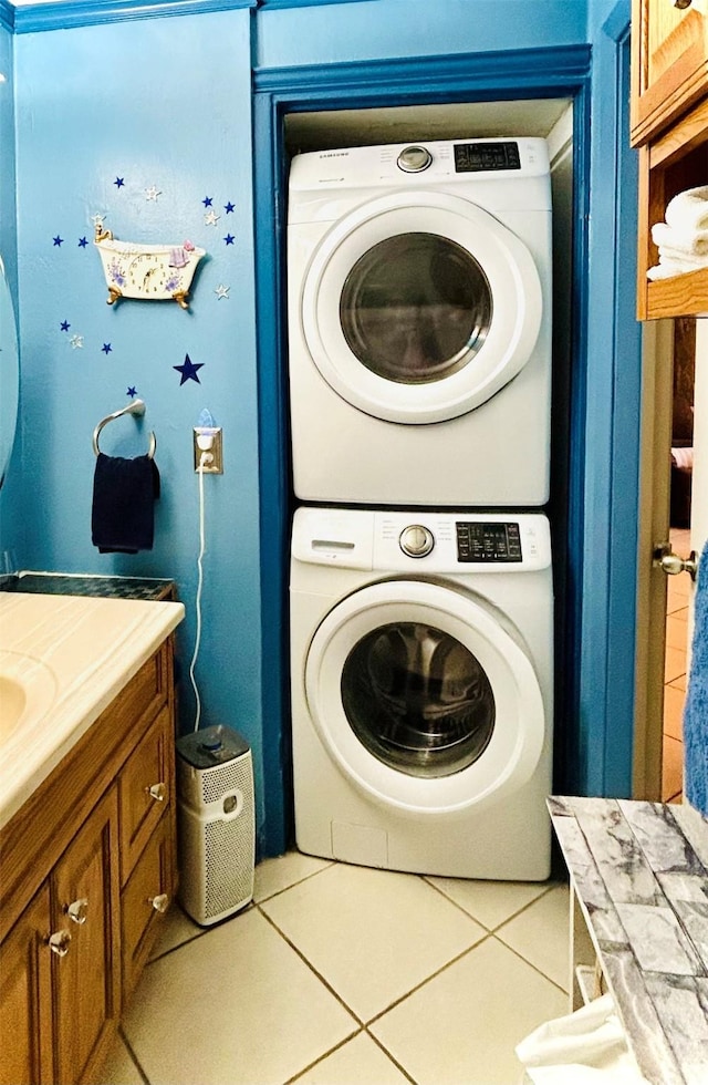 laundry area featuring laundry area, stacked washer and clothes dryer, and tile patterned floors