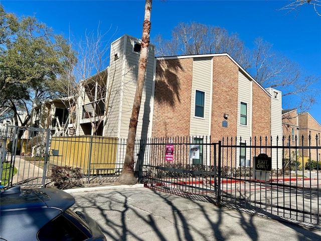 view of side of home featuring a chimney and fence