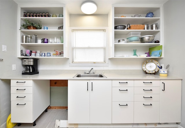 kitchen with sink, white cabinetry, and light wood-type flooring