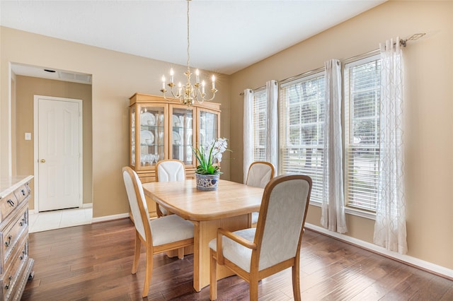 dining space featuring a notable chandelier, baseboards, and wood finished floors