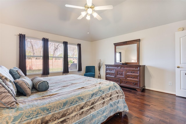 bedroom with dark wood-style floors, a ceiling fan, and baseboards