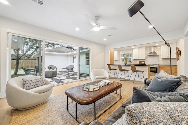 living room featuring ceiling fan and light hardwood / wood-style flooring