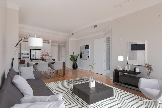 living room with ornamental molding and light hardwood / wood-style flooring