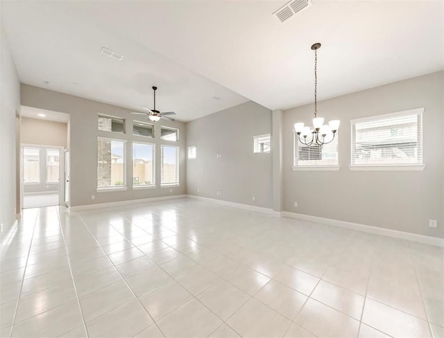 tiled empty room with ceiling fan with notable chandelier