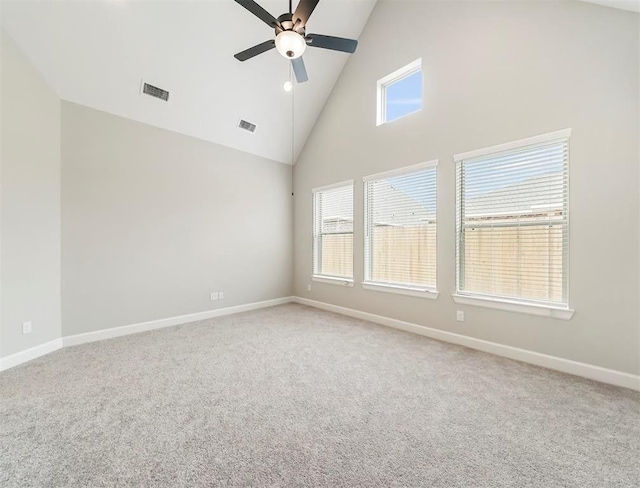 unfurnished room with ceiling fan, plenty of natural light, carpet flooring, and high vaulted ceiling