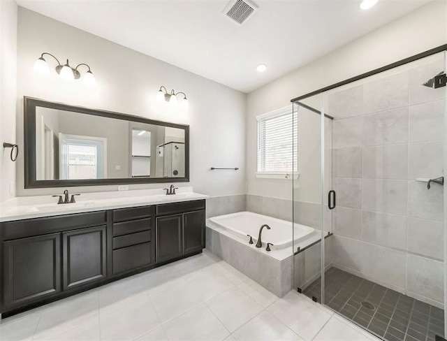 bathroom with plus walk in shower, a wealth of natural light, vanity, and tile patterned floors