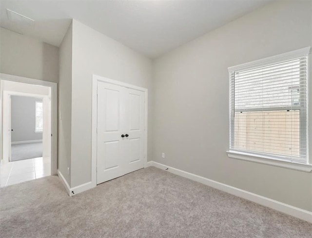 unfurnished bedroom featuring light carpet and a closet