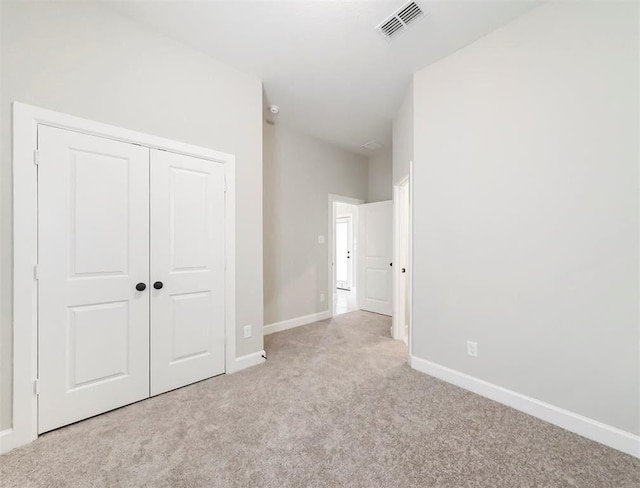 unfurnished bedroom featuring a closet and light carpet