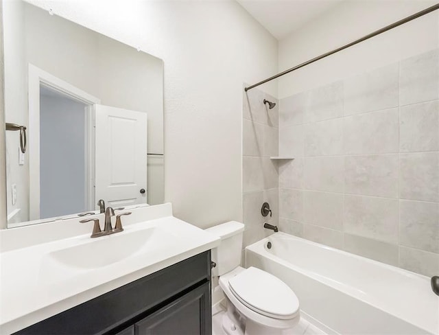 full bathroom with tiled shower / bath, vanity, and toilet