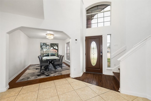 tiled entryway featuring a towering ceiling