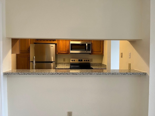 kitchen featuring light stone counters and appliances with stainless steel finishes