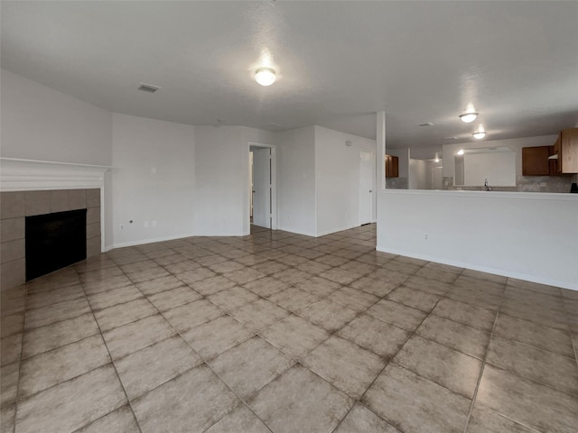 unfurnished living room with a tiled fireplace