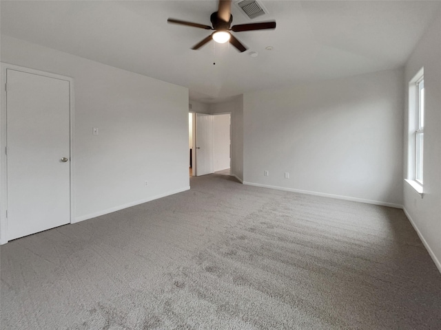 carpeted spare room featuring ceiling fan