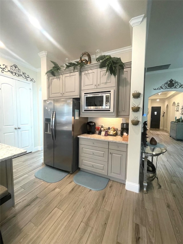 kitchen featuring gray cabinetry, light hardwood / wood-style flooring, and appliances with stainless steel finishes