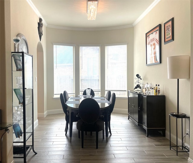 dining space featuring wood-type flooring, plenty of natural light, and ornamental molding