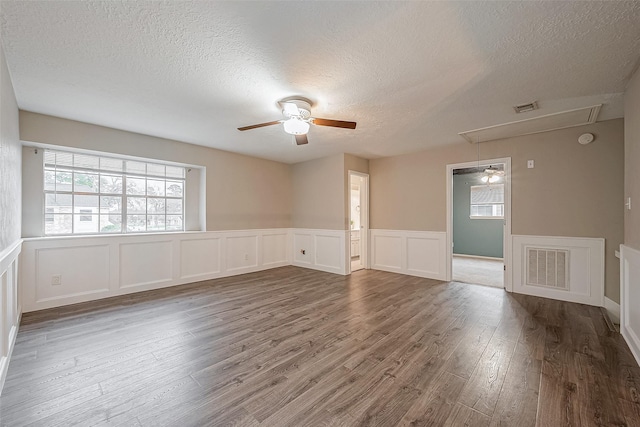 spare room featuring ceiling fan, dark hardwood / wood-style floors, and a textured ceiling