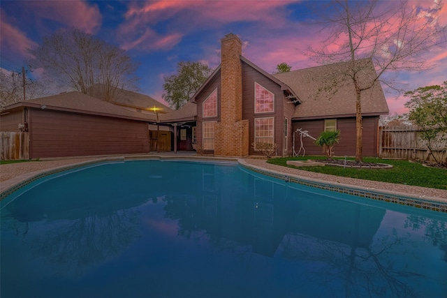 view of pool at dusk