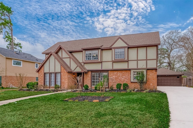 tudor home featuring a garage and a front lawn