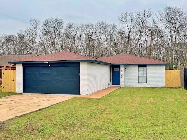 single story home featuring a garage and a front lawn