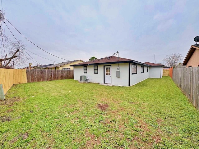 back of property featuring central AC unit and a lawn