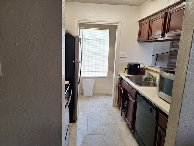 kitchen with light tile patterned flooring, stainless steel fridge, dishwasher, and sink