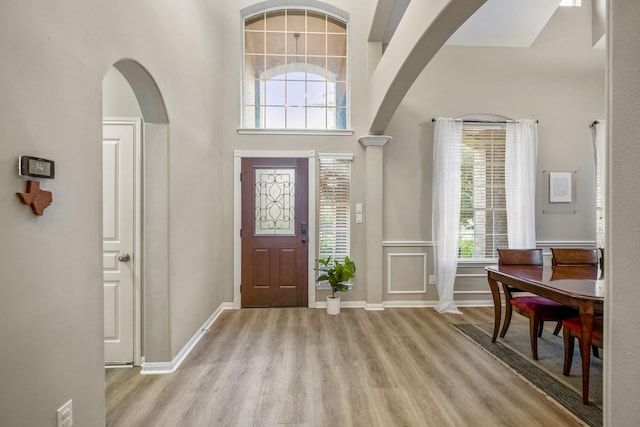 entrance foyer with a towering ceiling and light hardwood / wood-style flooring