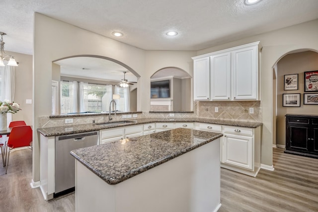 kitchen featuring sink, stainless steel dishwasher, white cabinets, and kitchen peninsula