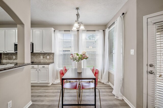 dining room with a textured ceiling and light wood-type flooring