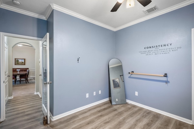 interior space with ceiling fan, ornamental molding, and hardwood / wood-style floors