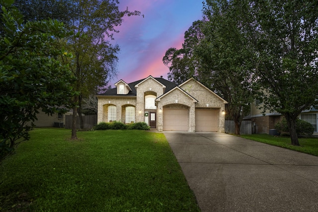 view of front of house featuring a garage and a yard