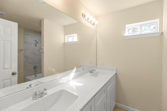 bathroom with vanity and tiled shower / bath combo