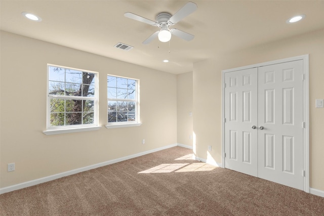 unfurnished bedroom with light colored carpet, a closet, and ceiling fan