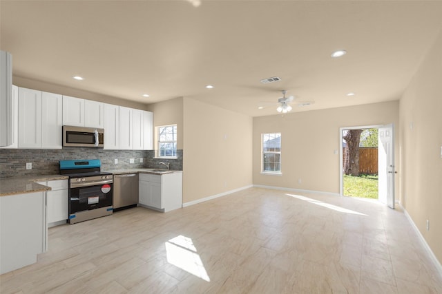 kitchen featuring backsplash, sink, white cabinets, and appliances with stainless steel finishes