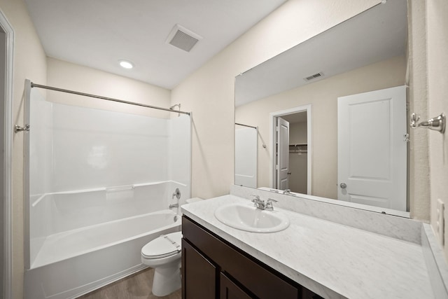 full bathroom with toilet, hardwood / wood-style floors, vanity, and shower / bathing tub combination