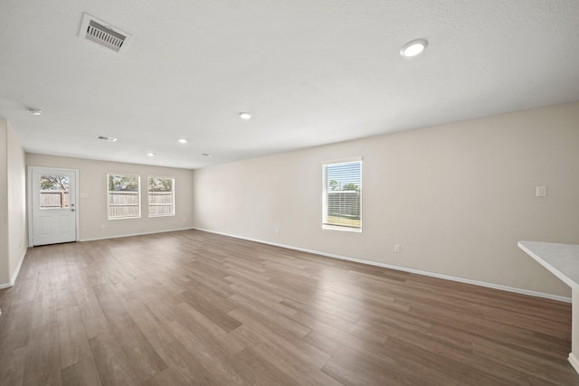 spare room featuring a healthy amount of sunlight and hardwood / wood-style floors