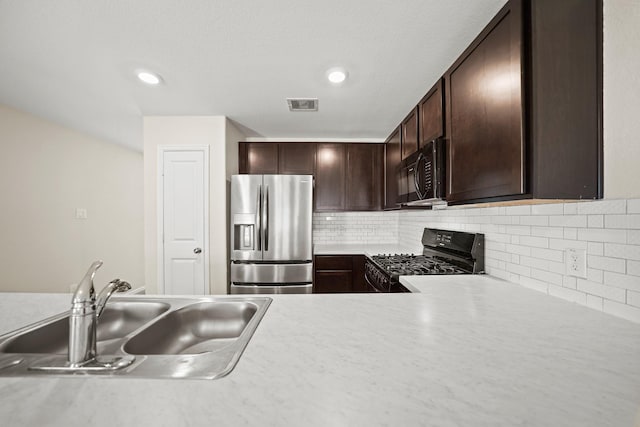 kitchen with dark brown cabinetry, sink, tasteful backsplash, and black appliances