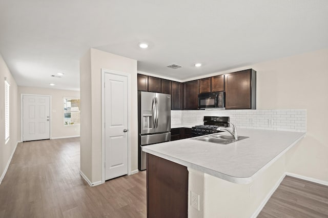 kitchen featuring dark brown cabinetry, light hardwood / wood-style floors, sink, and black appliances