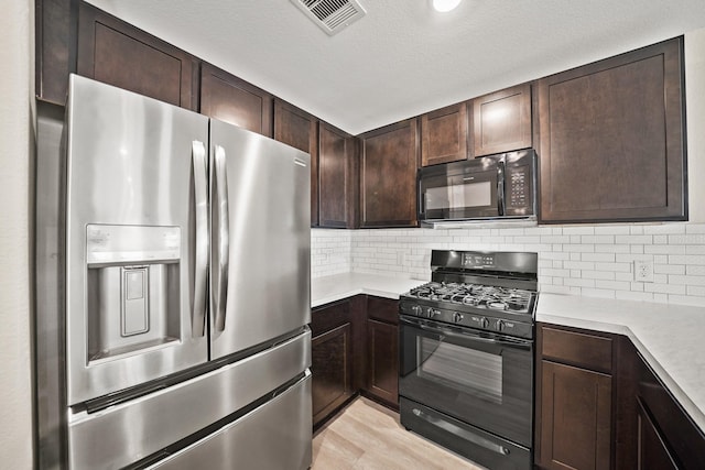 kitchen with dark brown cabinets, backsplash, light wood-type flooring, and black appliances