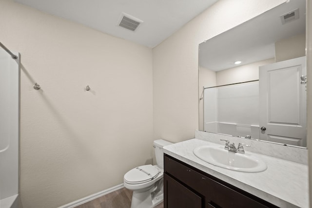 bathroom with vanity, toilet, hardwood / wood-style floors, and walk in shower