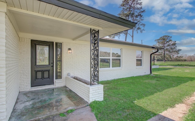 entrance to property featuring a lawn