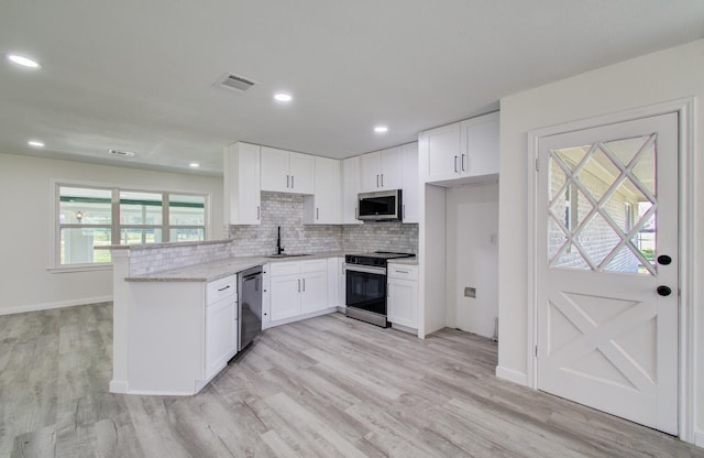 kitchen featuring white cabinetry, sink, stainless steel appliances, and decorative backsplash