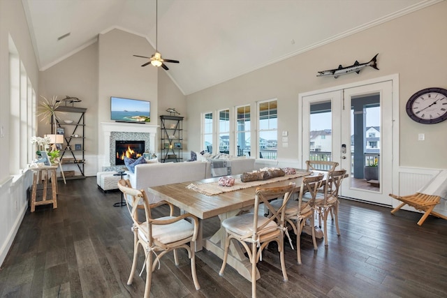 dining area with french doors, high vaulted ceiling, ornamental molding, dark hardwood / wood-style floors, and a tiled fireplace