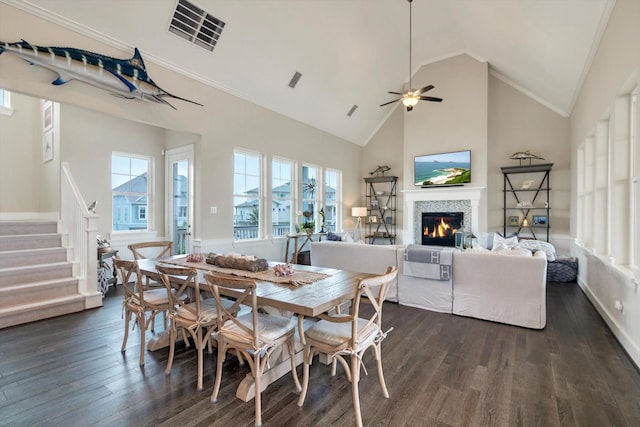 dining area with dark hardwood / wood-style flooring, ornamental molding, plenty of natural light, and high vaulted ceiling